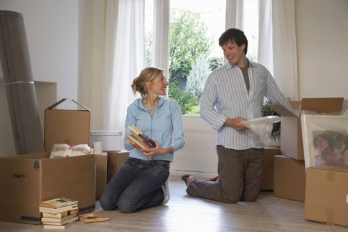 Local movers carrying boxes and furniture through an Upminster street
